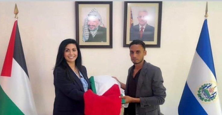سعادة الدكتورة رينا حناوي فتوح، سفيرة دولة فلسطين لدى السلفادور، تقدم علمًا فلسطينيًا للسيد رافائيل موران، سيُوضع في ساحة السيد المسيح الفلسطيني في مدينة سونسوناتي
